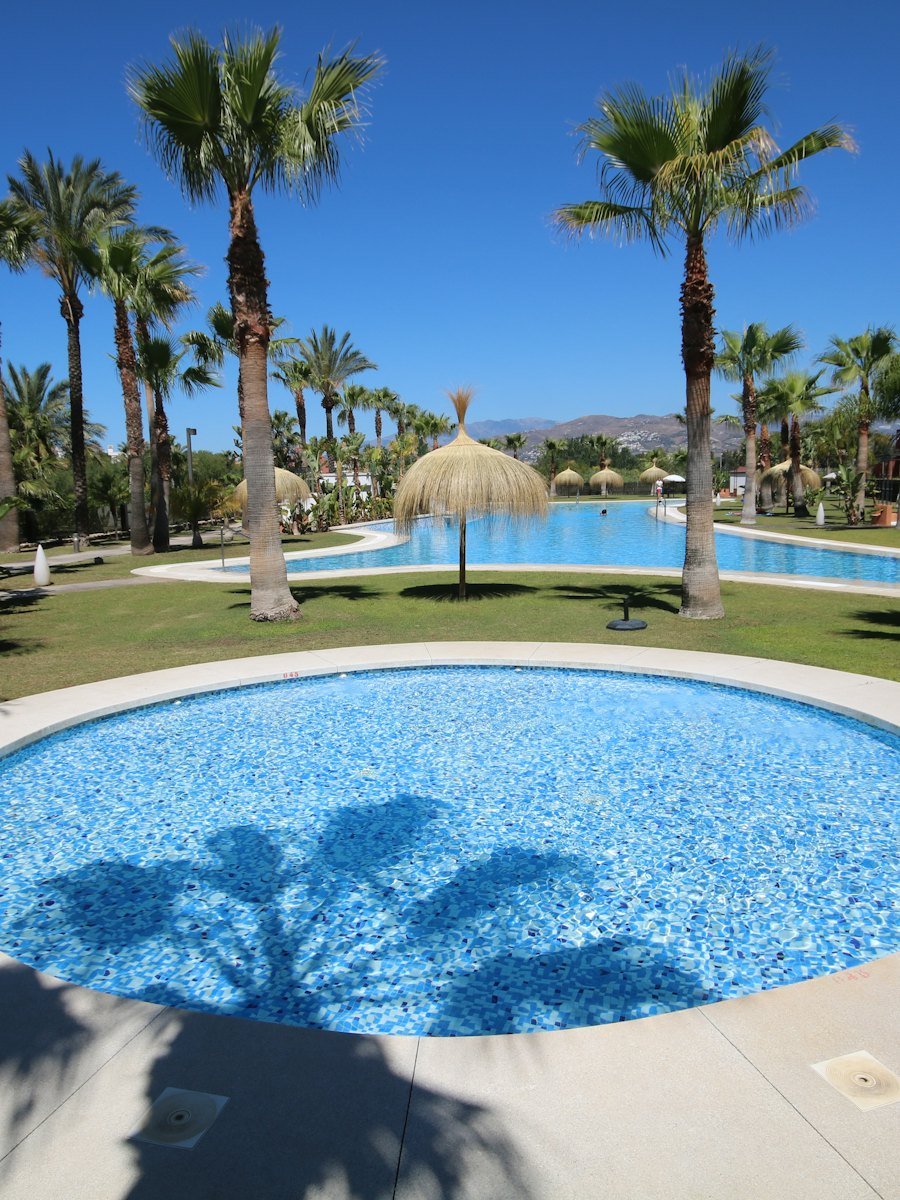 Rond zwembad tussen palmbomen in een Andalusisch resort
