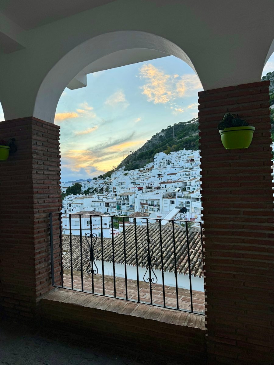 Uitzicht door een Andalusische boog op een wit dorp in de bergen